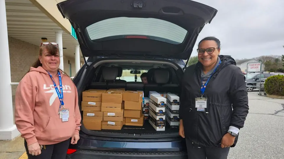 Two people from an animal rescue organization picking up pet food as part of Ocean State Job Lot’s To The Rescue pet food donation program.
